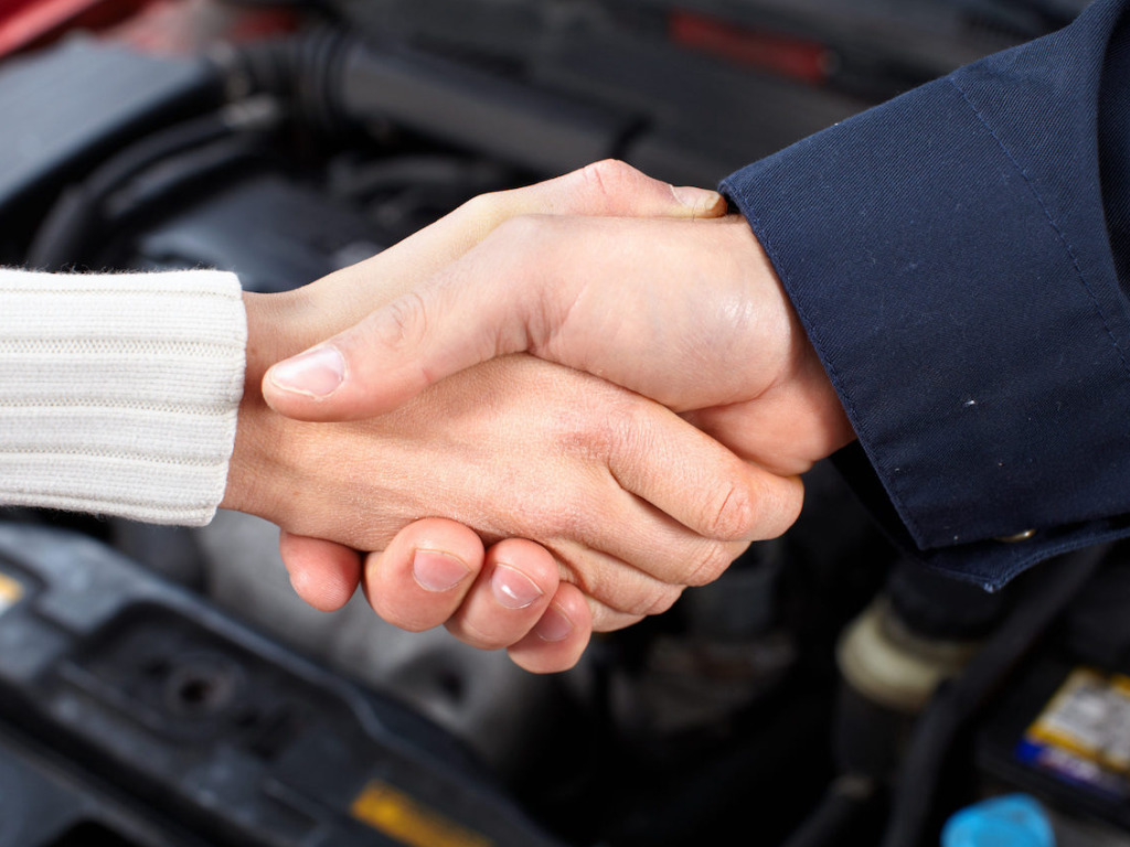 A woman and a mechanic shaking hands