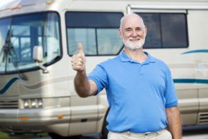 Man giving a thumbs up in front of an RV